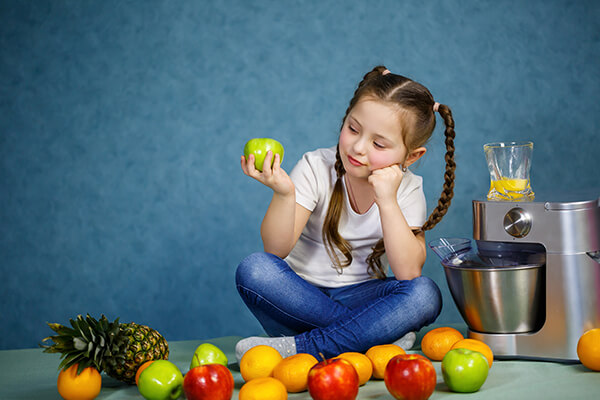 A girl kids looking at fruits suggested by best kids nutritionist in patiala, punjab